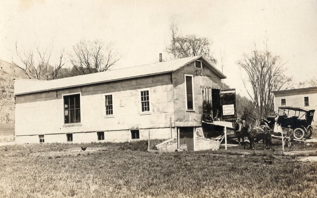 an old garage in Randolph with a car on an inclined ramp leading in to the garage
