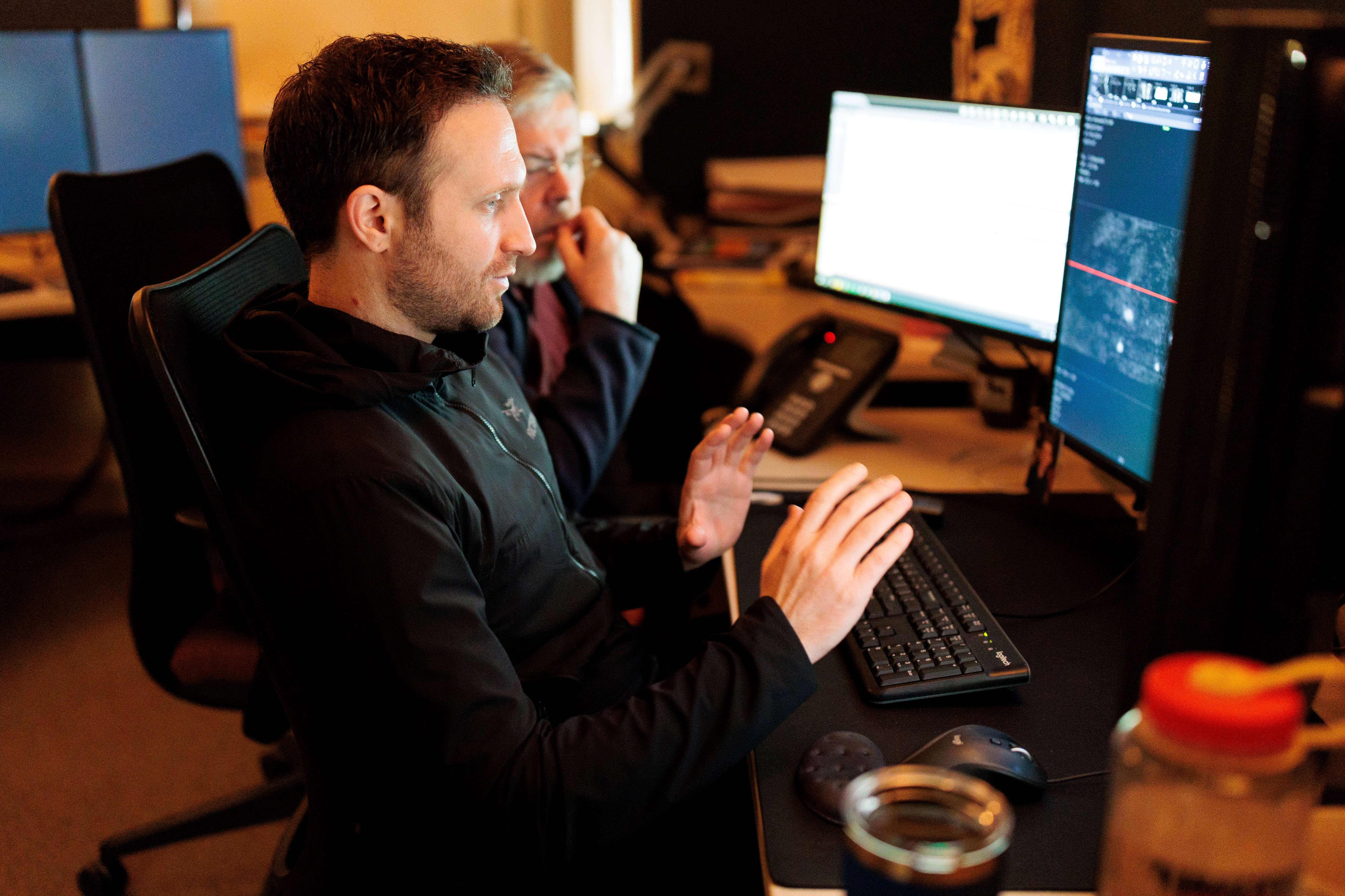 Man sitting and observing a computer monitor