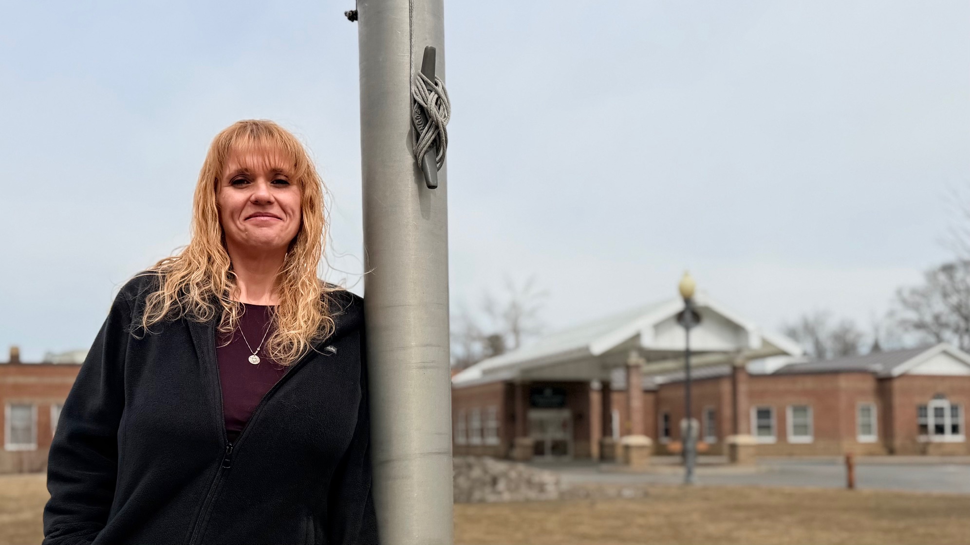 woman leaning against a flag pole