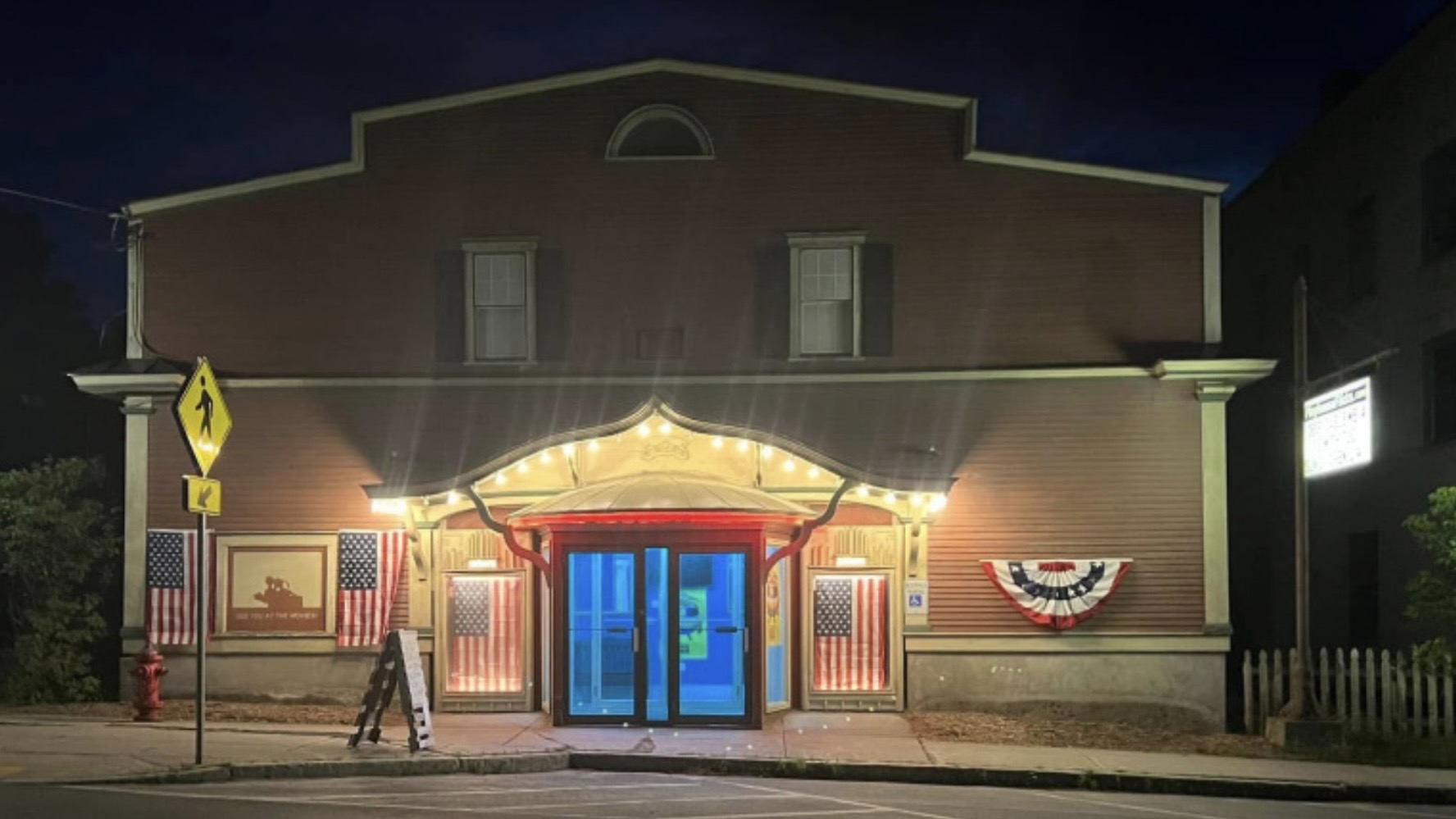 old style movie theater at night w lights up